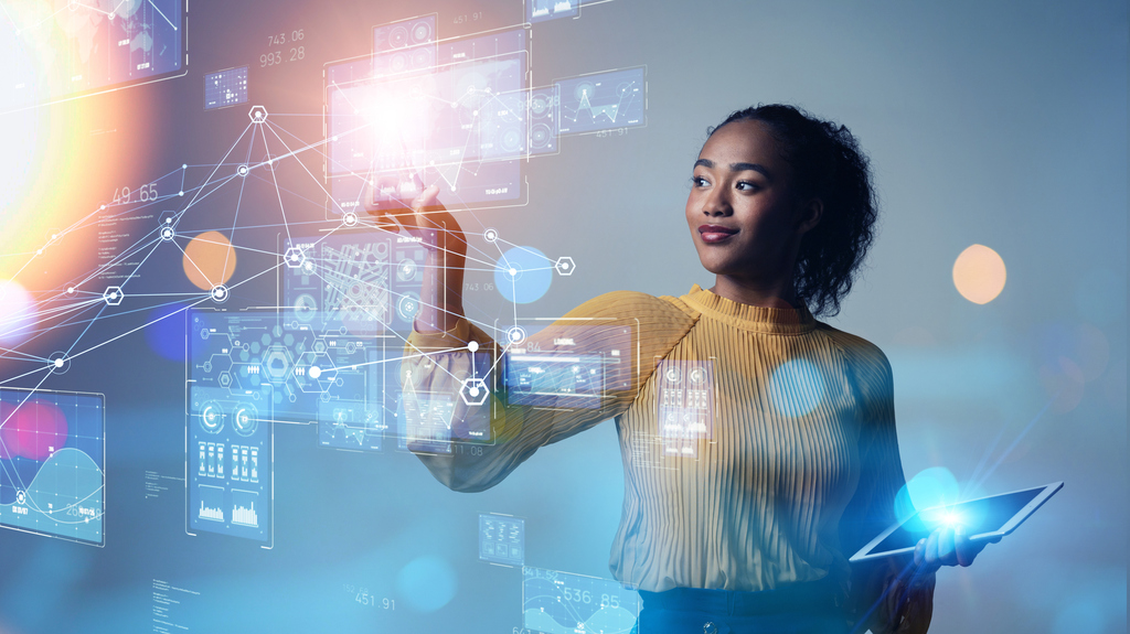 Frau interagiert mit digitalen Grafiken und Daten auf einem virtuellen Interface.